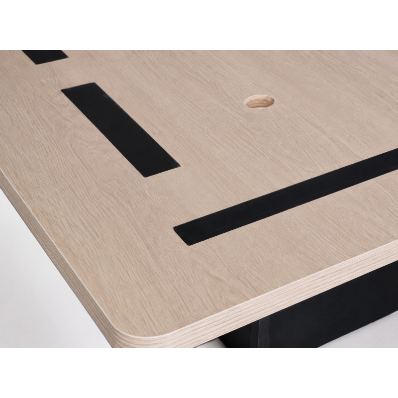 Close-up of a Hilton-standard bed base showing the rounded front safety corners and 1-inch wide black non-skid strips for mattress security.