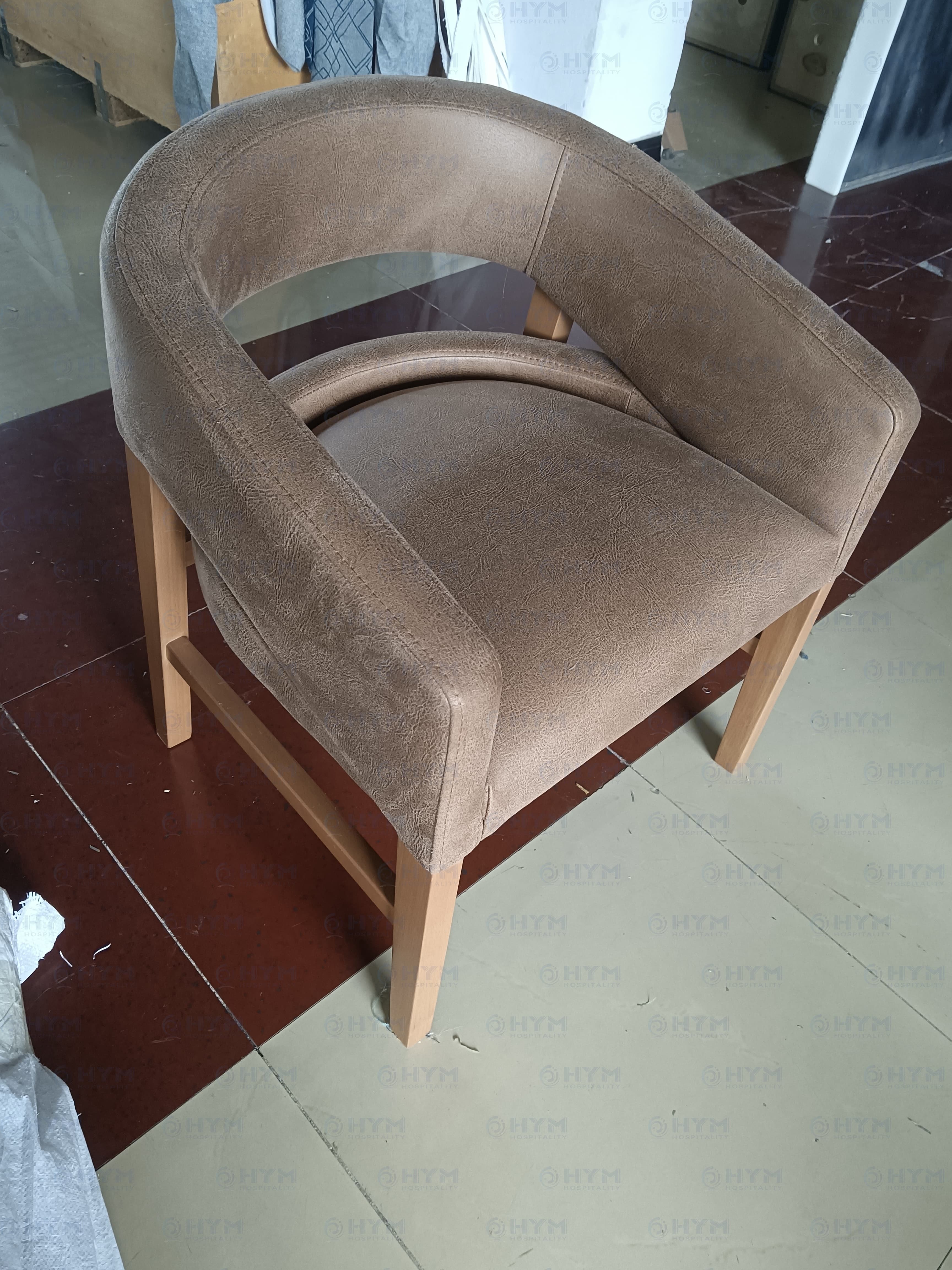 Marriott brand-compliant upholstered lounge chair for Fairfield Inn & Suites guestrooms, featuring a contoured wrap-around back, textured faux-leather finish, and solid wood legs for contract-grade durability.
