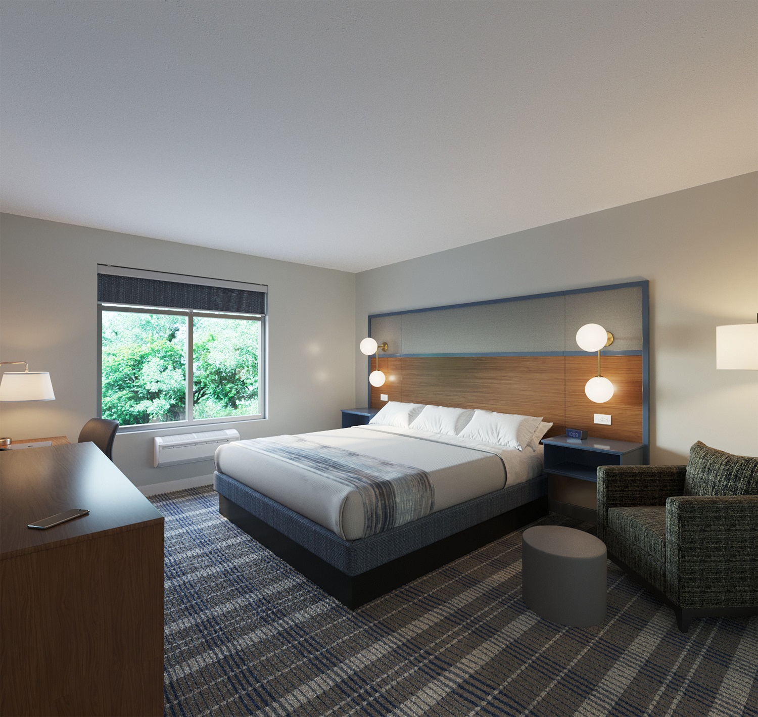 Modern AmericInn Hotel & Suites guestroom interior featuring a king bed with integrated headboard, built-in wall lamps, and a functional desk area by the window.