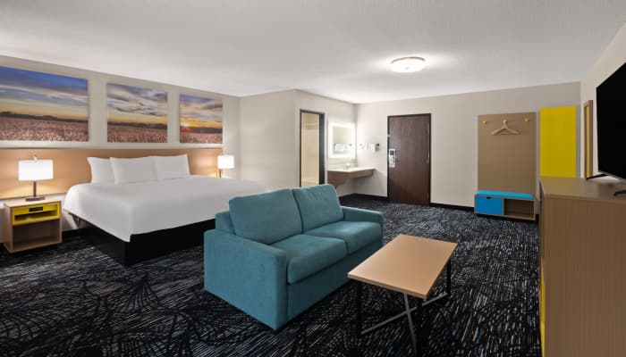 Full suite view of a Days Inn by Wyndham "Dawn" prototype room, featuring our turnkey FF&E collection including the signature blue upholstered bench.