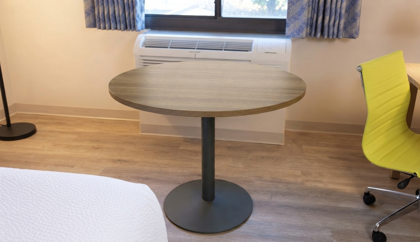Brand-standard Days Inn activity table GR-312 with black metal pedestal base, positioned for optimal space efficiency in a standard room.