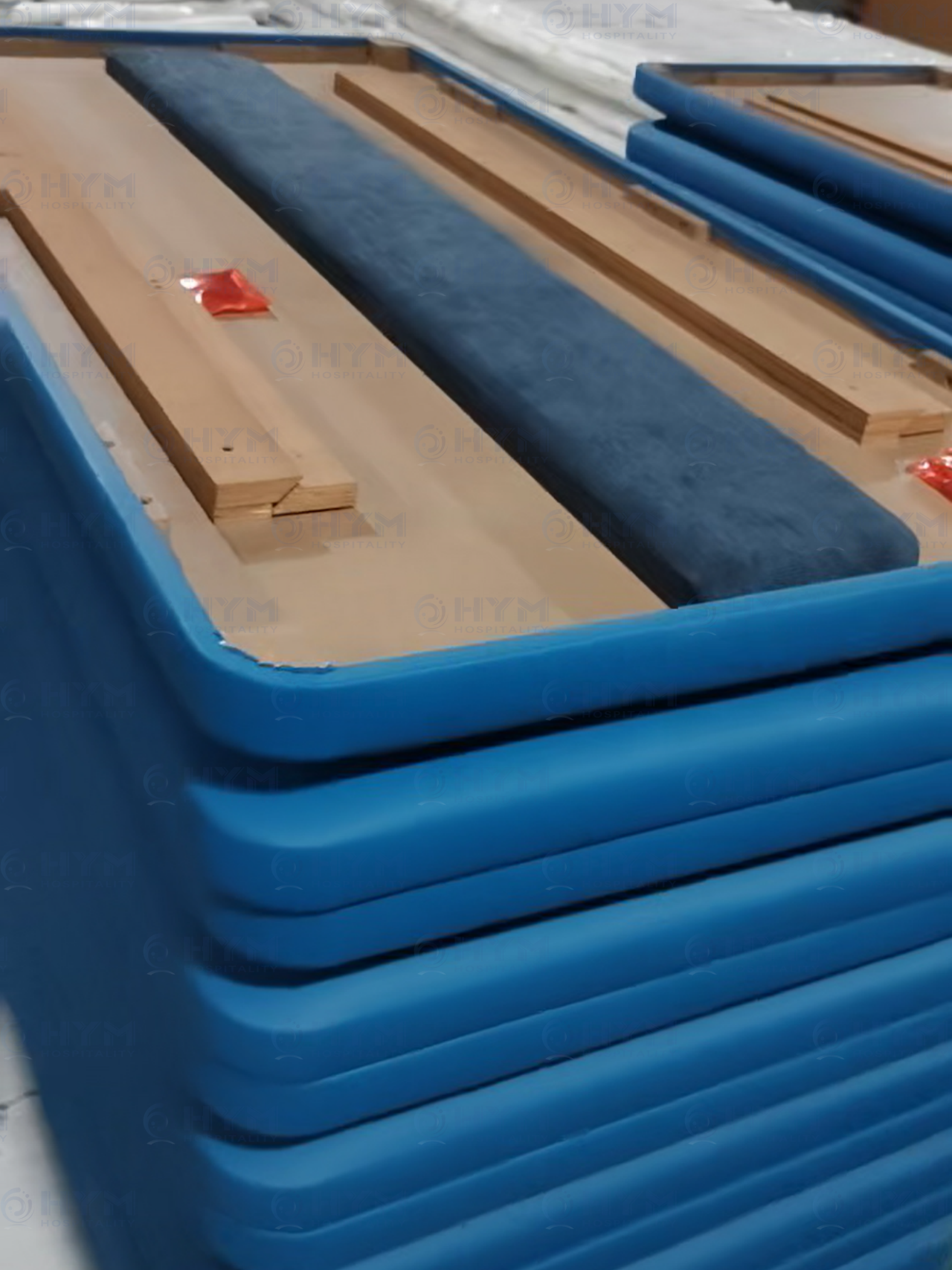 Stack of audit-ready Hampton by Hilton headboards in the Hyman factory, demonstrating mass production capacity and reinforced back-side engineering.