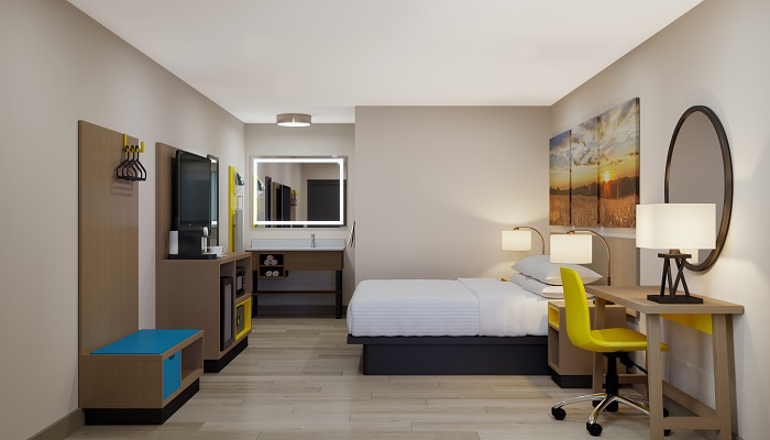 Modernized Days Inn guestroom interior showcasing the GR-305 bench integrated with a coordinated wardrobe and vanity for a seamless "Dawn" identity.
