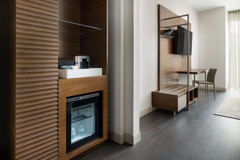 Architectural slatted wood closet system and integrated micro-fridge cabinet, precision-milled for AC Hotels by Marriott brand standards.