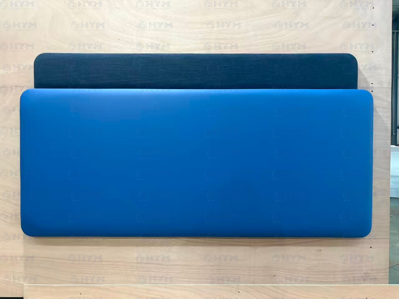 Factory production sample of a Hampton by Hilton Queen headboard featuring two-tier blue performance upholstery and reinforced internal frame.