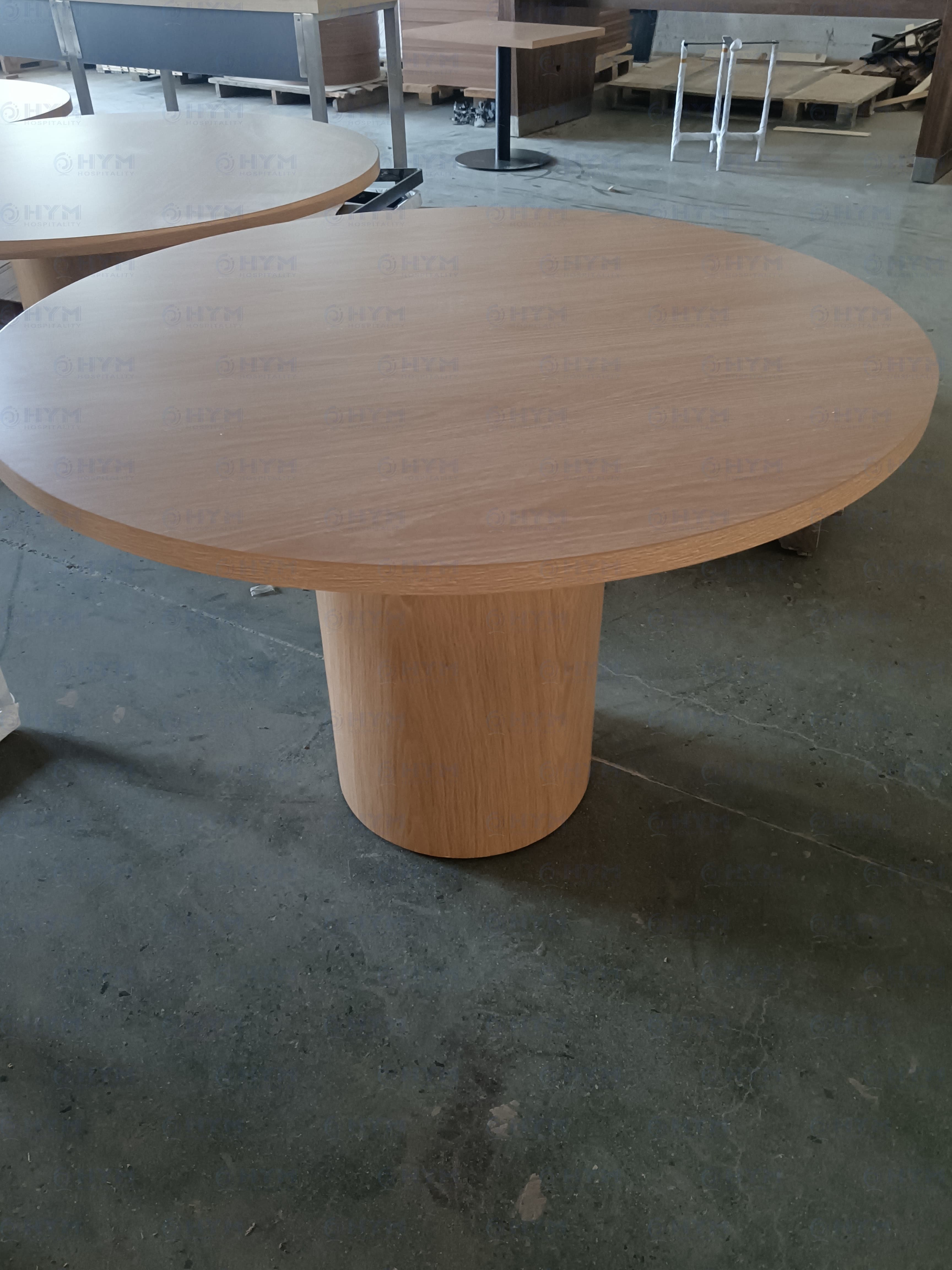 Marriott-compliant round pedestal dining and work table for Fairfield Inn & Suites guestrooms, featuring a light oak finish and reinforced cylindrical base for high-traffic hospitality use.