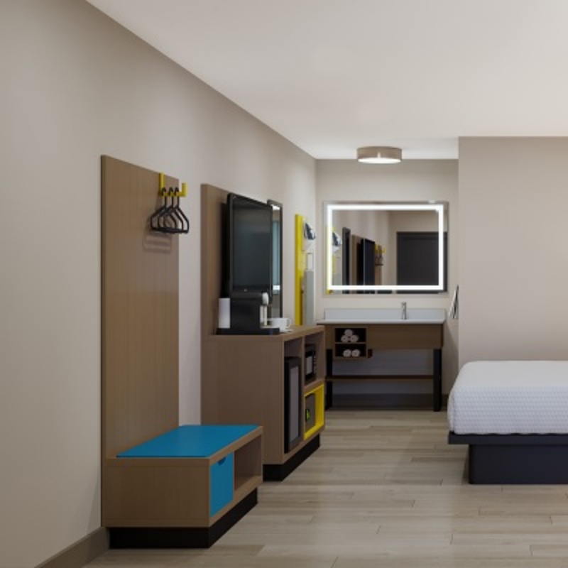 Complete guestroom furniture layout for Days Inn by Wyndham "Dawn" scheme, showcasing the seamless flow between the open closet system, media unit, and vanity area.