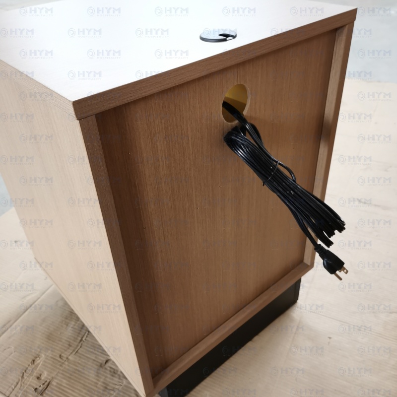 Back view of a hospitality nightstand showing precision-cut cable management port and heavy-duty power cord with a 45-degree flat plug.